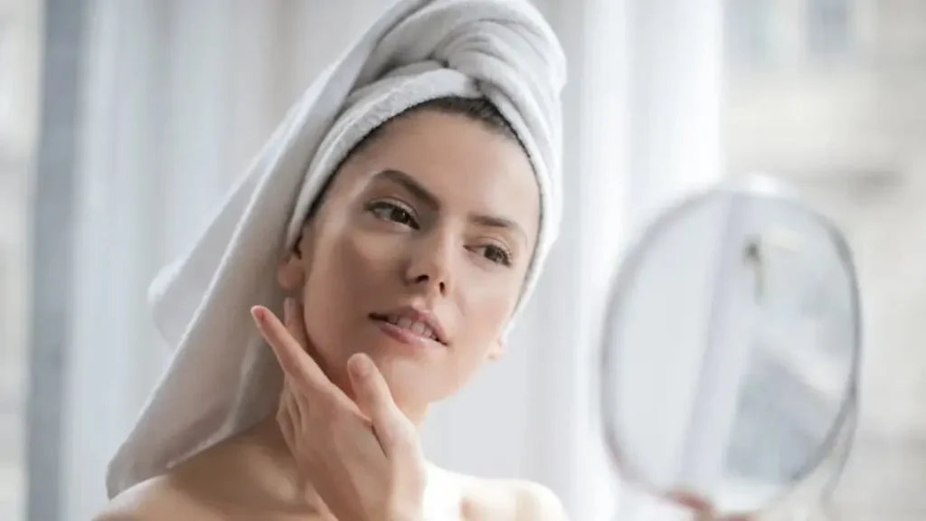 Woman Looking In Mirror With Towel On Head